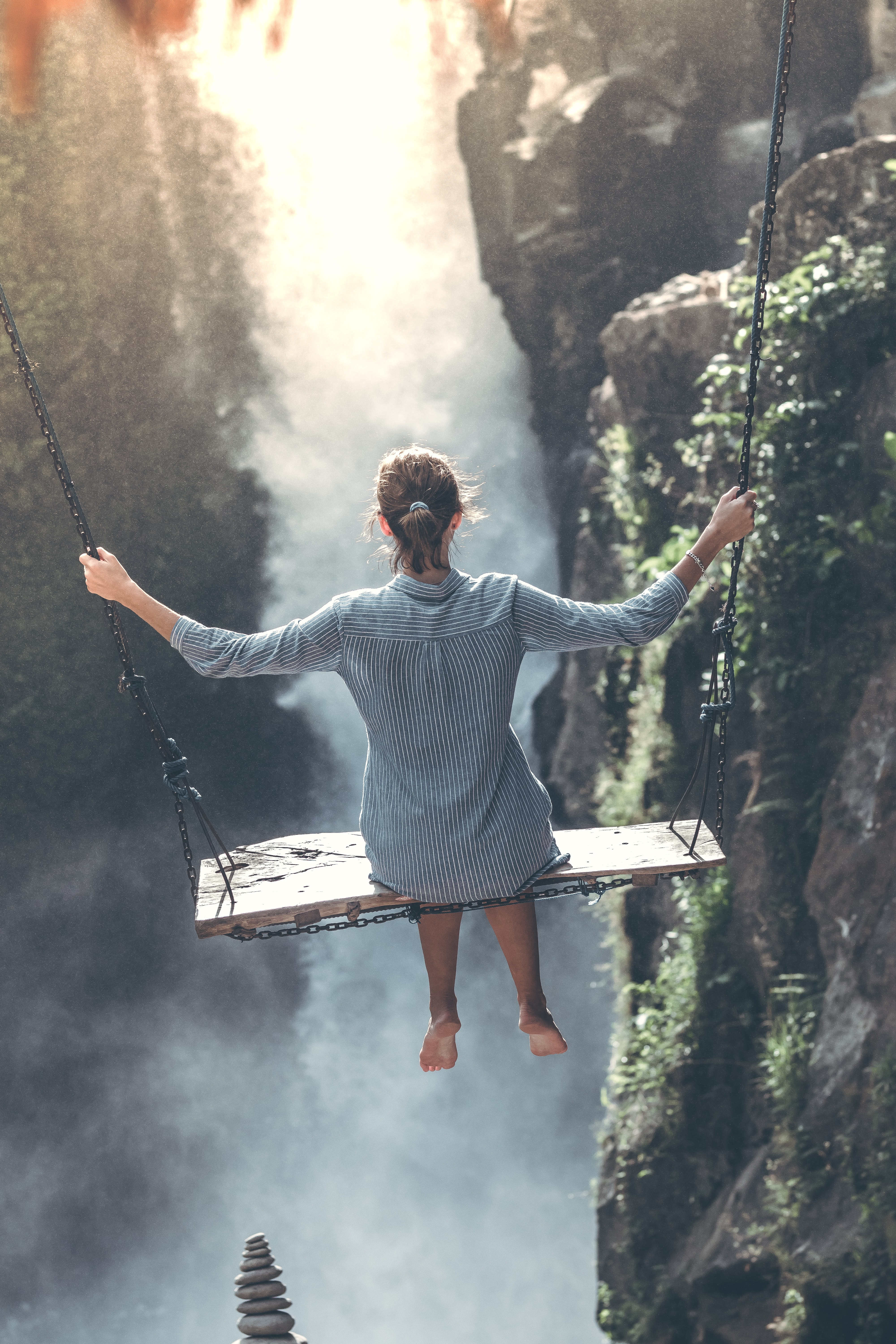 woman swinging over waterfall